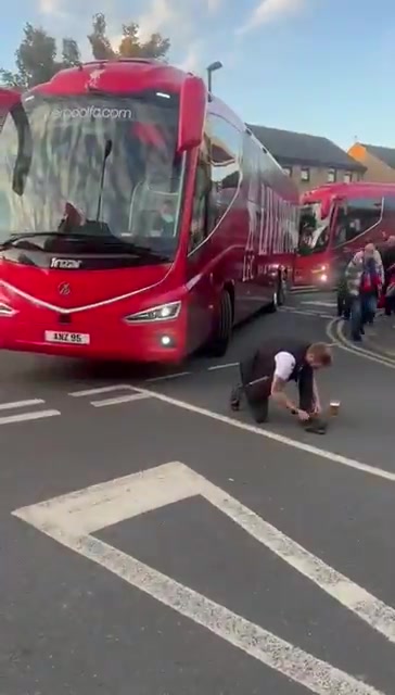 上嘴臉??利物浦大巴離開(kāi)時(shí)，一名水晶宮球迷故意蹲在車(chē)前系鞋帶